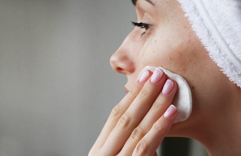 Acne sufferer cleanses face.